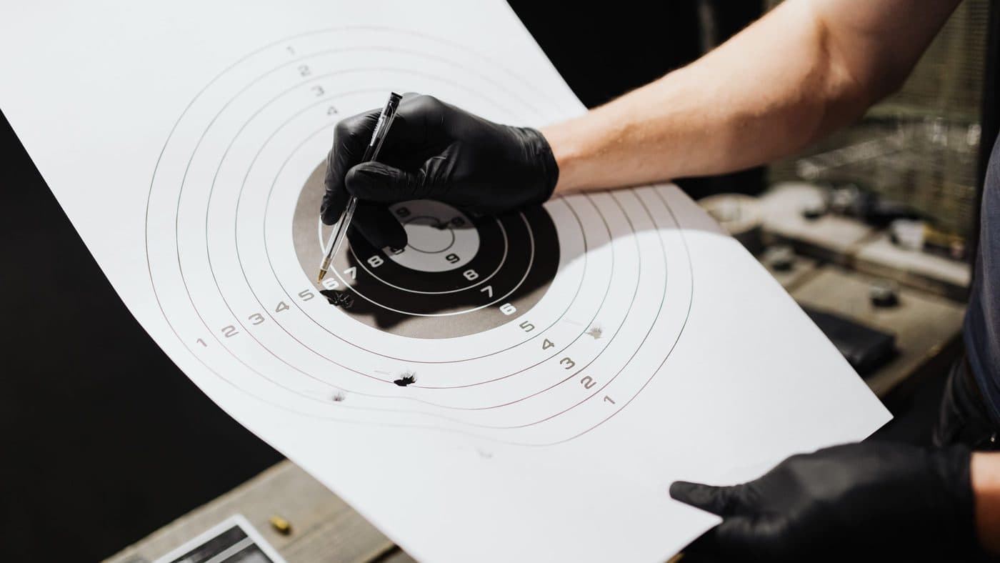 Students receiving instruction at an outdoor range during the live-fire portion of a pistol safety course