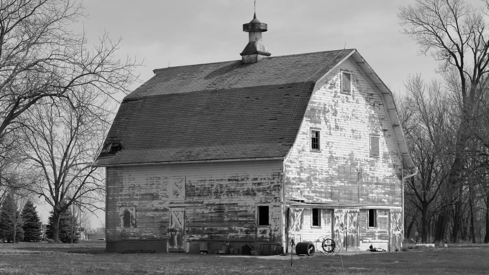 A weathered wooden barn standing in Iowa farmland